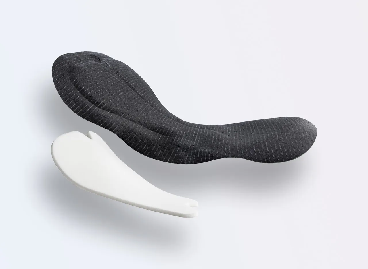 Deux coussinets de sport de différentes couleurs, l'un en noir avec un design texturé et l'autre en blanc avec une forme simple.